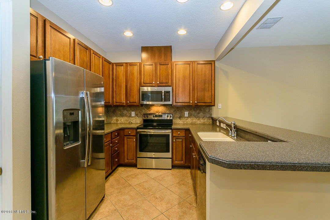 12991 Spring Rain Road Jacksonville, FL 32258 - Photo 2 of 23 a kitchen with kitchen island granite countertop a sink stainless steel appliances and cabinets