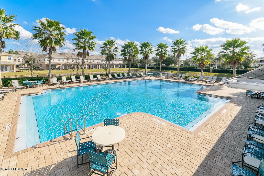 12991 Spring Rain Road Jacksonville, FL 32258 - Photo 22 of 23 a view of a swimming pool with a lawn chairs under an umbrella