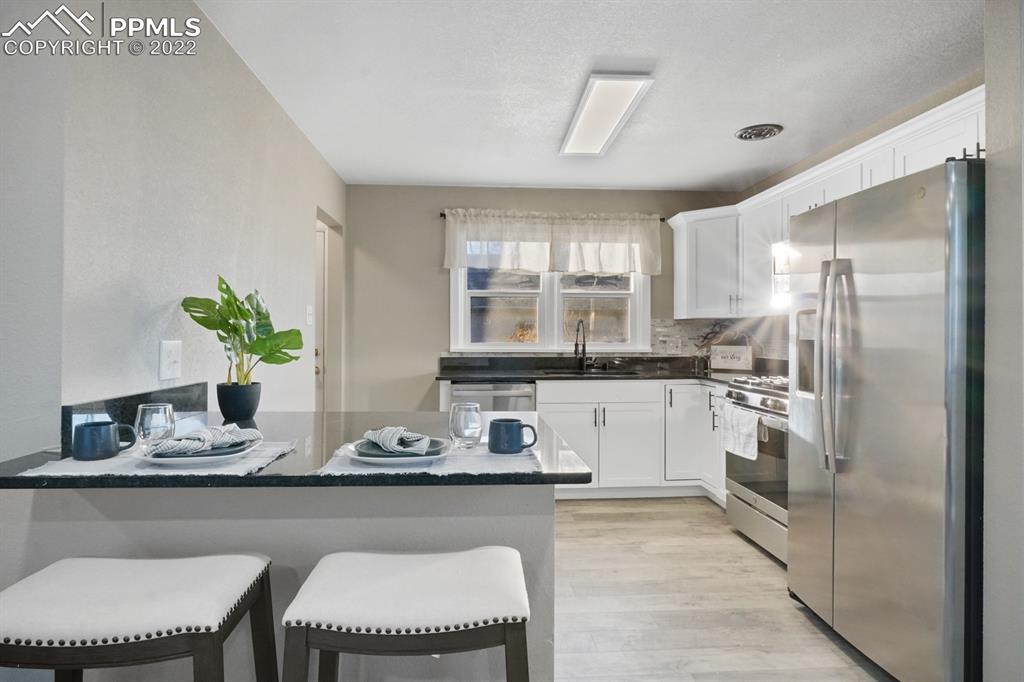 1901 Ridgewood Lane Pueblo, CO 81005 - Photo 8 of 29 a kitchen with a refrigerator and white cabinets