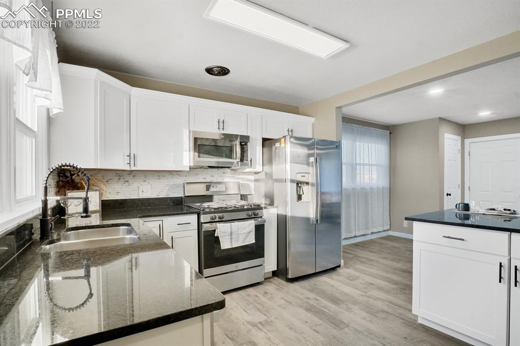 1901 Ridgewood Lane Pueblo, CO 81005 - Photo 9 of 29 a kitchen with stainless steel appliances granite countertop a stove a sink and a refrigerator