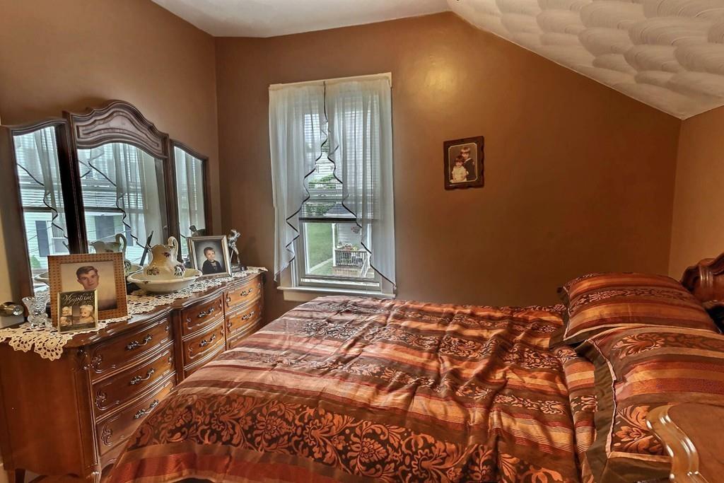 52 Smith Street Fall River, MA 02721 - Photo 8 of 13 a bedroom with a bed and a large mirror next to a window