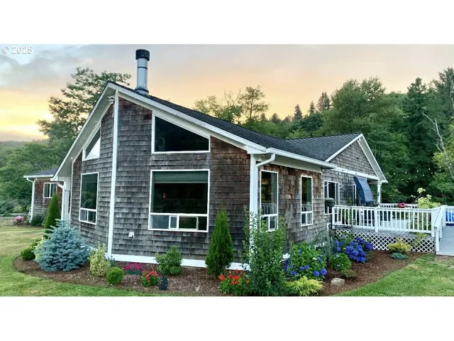 a black and white house with a yard and potted plants