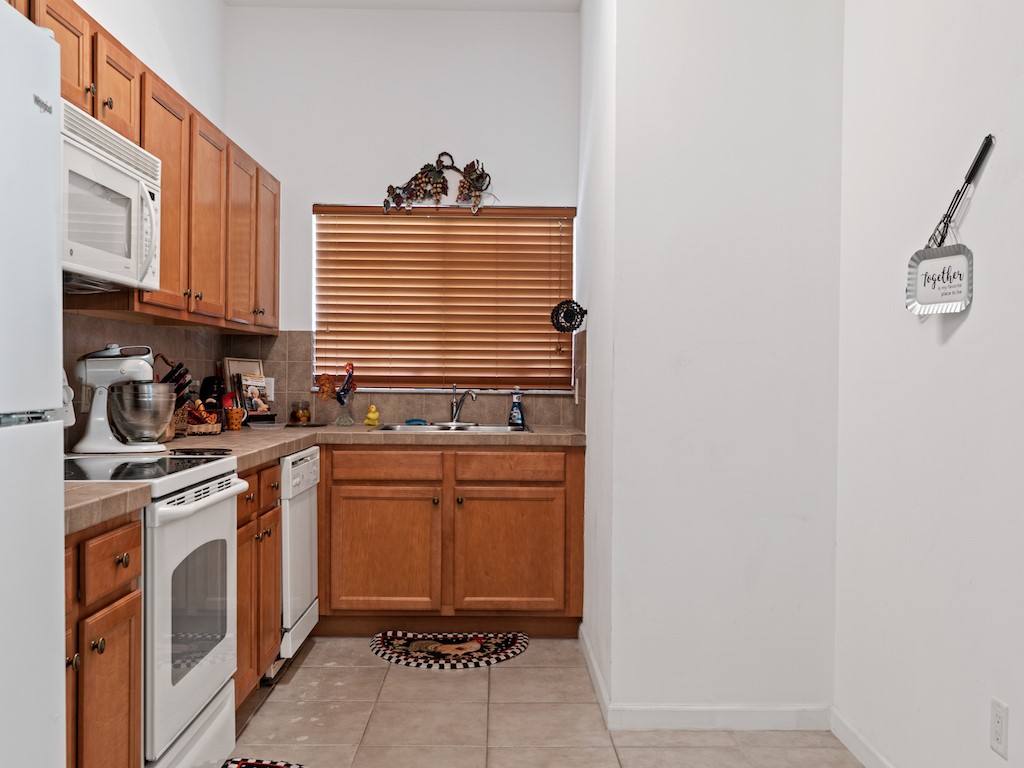 572 7th Square Southwest, Unit 101 Vero Beach, FL 32962 - Photo 12 of 34 a kitchen with stainless steel appliances granite countertop a sink and cabinets