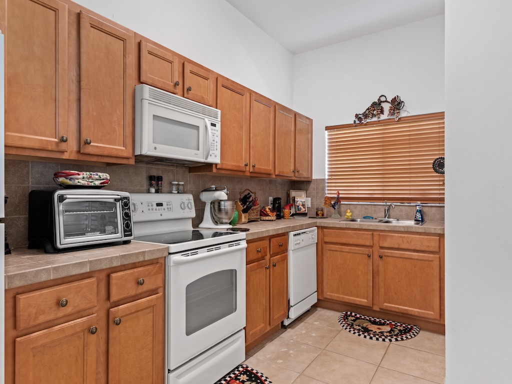572 7th Square Southwest, Unit 101 Vero Beach, FL 32962 - Photo 13 of 34 a kitchen with stainless steel appliances granite countertop a sink stove and cabinets
