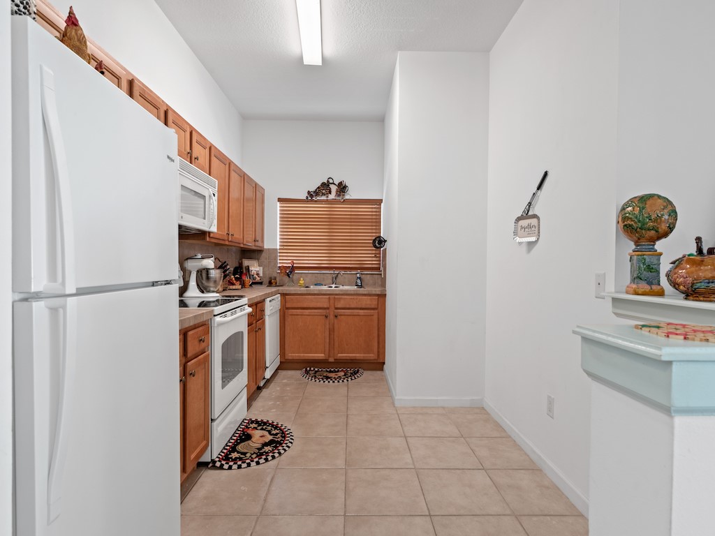 572 7th Square Southwest, Unit 101 Vero Beach, FL 32962 - Photo 14 of 34 a kitchen with a refrigerator sink and stove