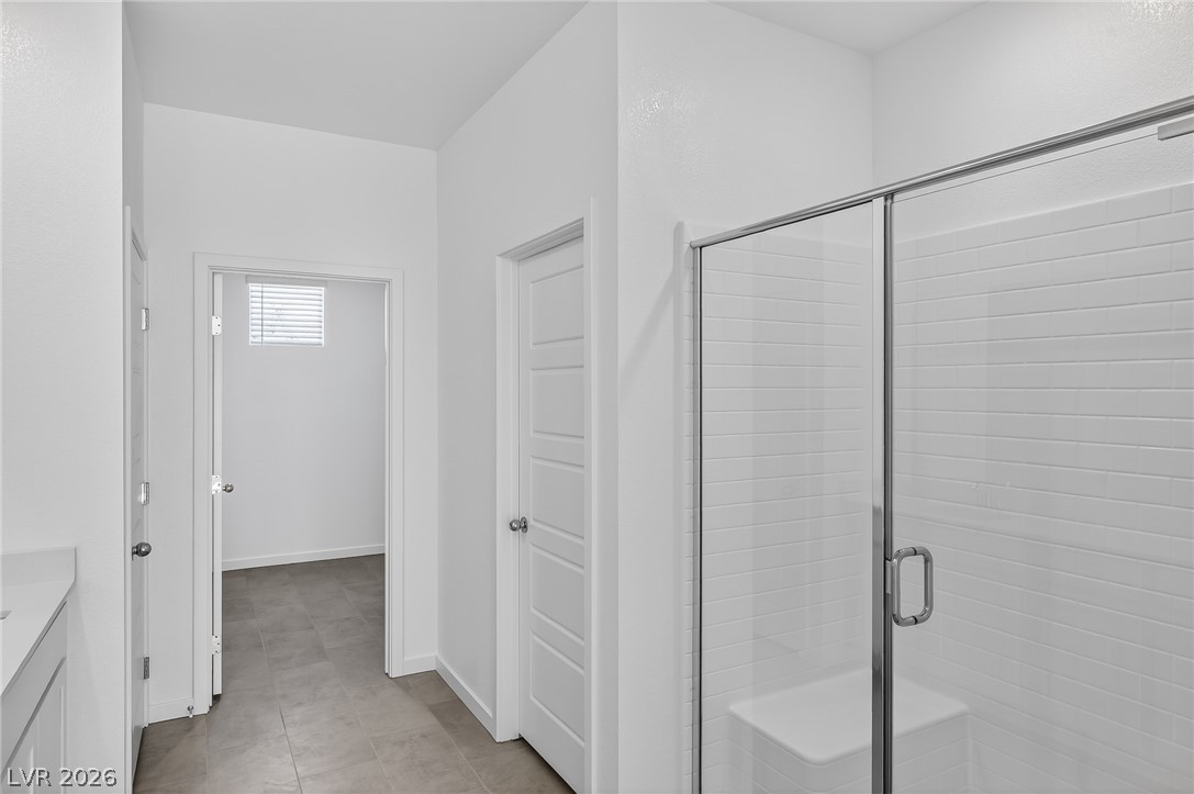347 Sam Way Mesquite, NV 89027 - Photo 22 of 32 A well-lit corridor leads to a pristine bathroom with a sleek glass-enclosed shower.