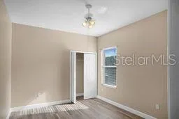 a view of a bedroom with wooden floor and windows
