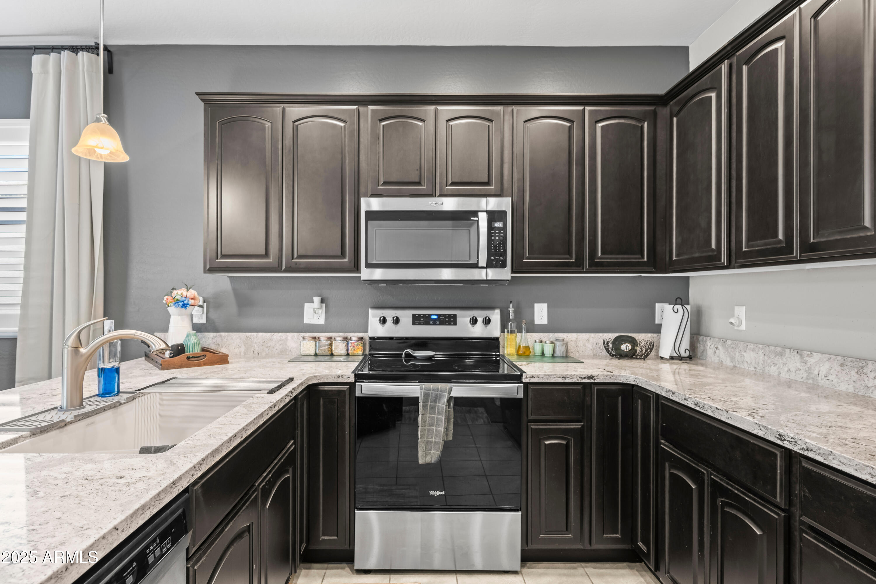 3117 South Signal Butte Road, Unit 474 Mesa, AZ 85212 - Photo 8 of 24 a kitchen with stainless steel appliances granite countertop a stove a sink and a microwave