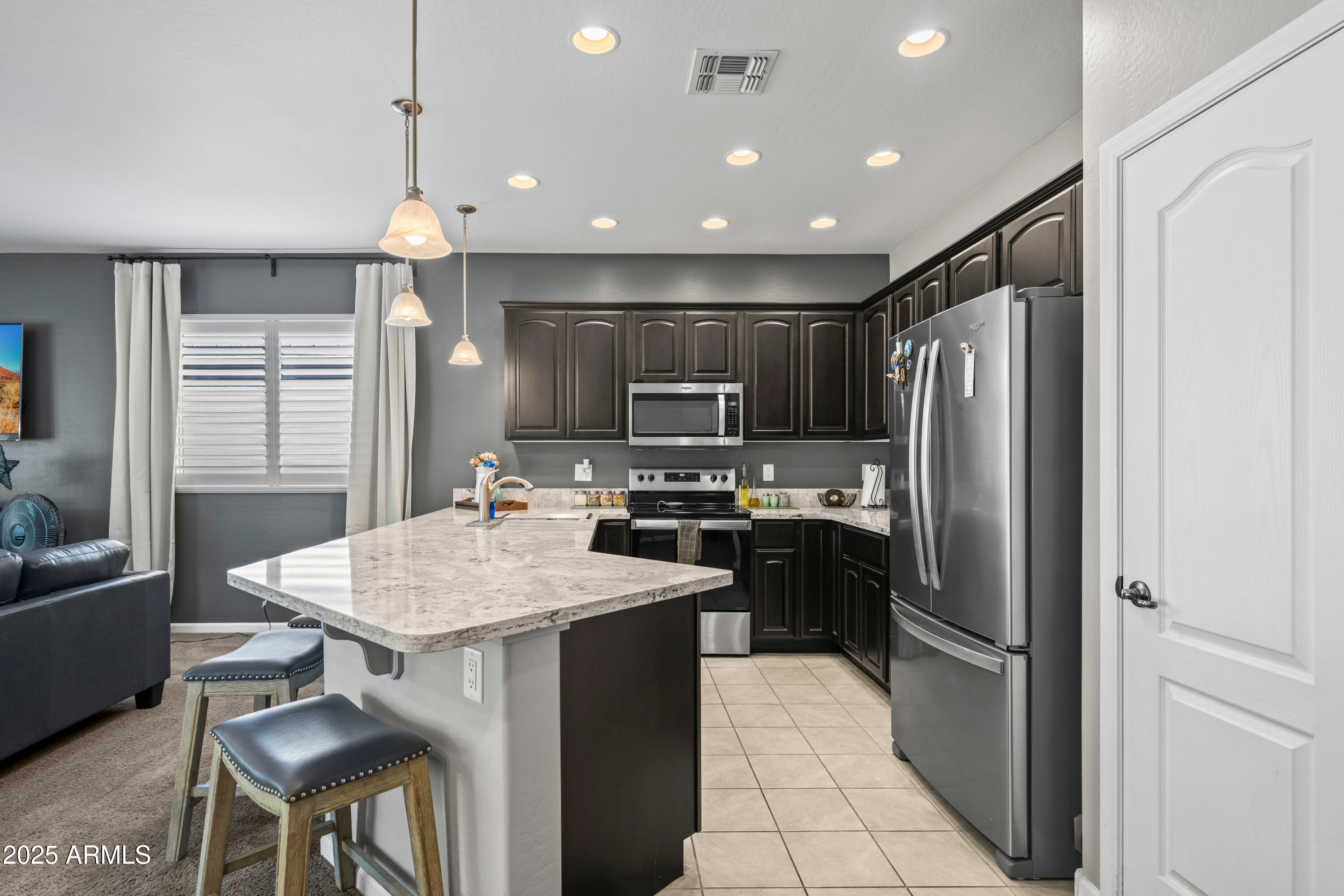 3117 South Signal Butte Road, Unit 474 Mesa, AZ 85212 - Photo 9 of 24 a kitchen with stainless steel appliances granite countertop a refrigerator a sink dishwasher a stove and a refrigerator with wooden floor