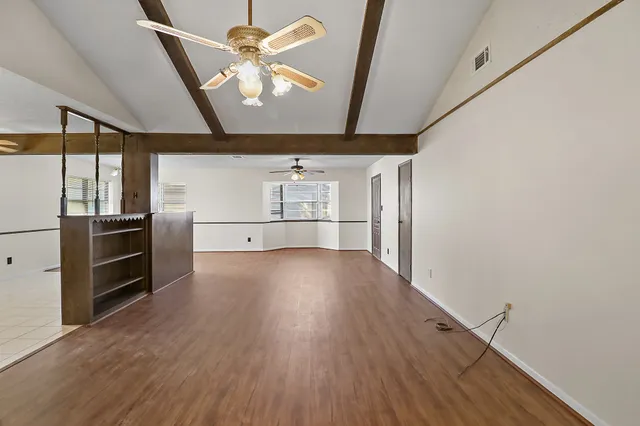 a view of empty room with wooden floor