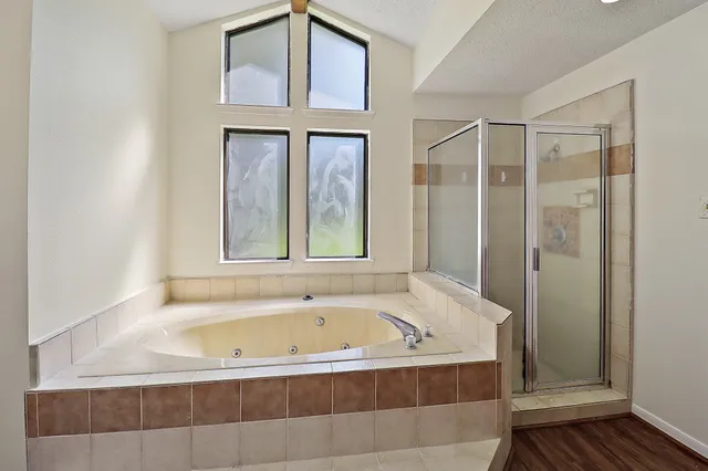 a bathroom with a tub a sink and a window