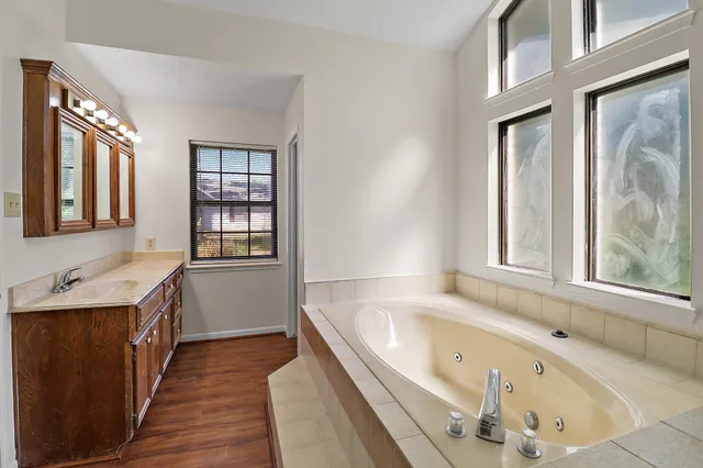 a bathroom with a granite countertop sink and a window