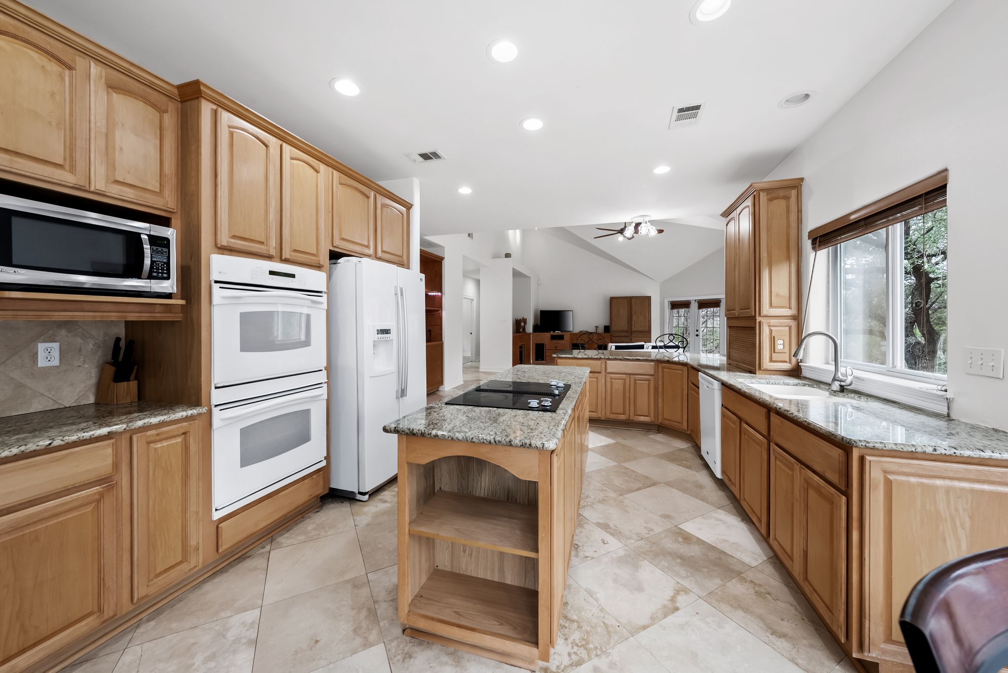 200 Vista West Ranch Road Dripping Springs, TX 78620 - Photo 7 of 20 Kitchen featuring granite countertops, wood cabinetry, built-in double ovens, and a central island with a cooktop