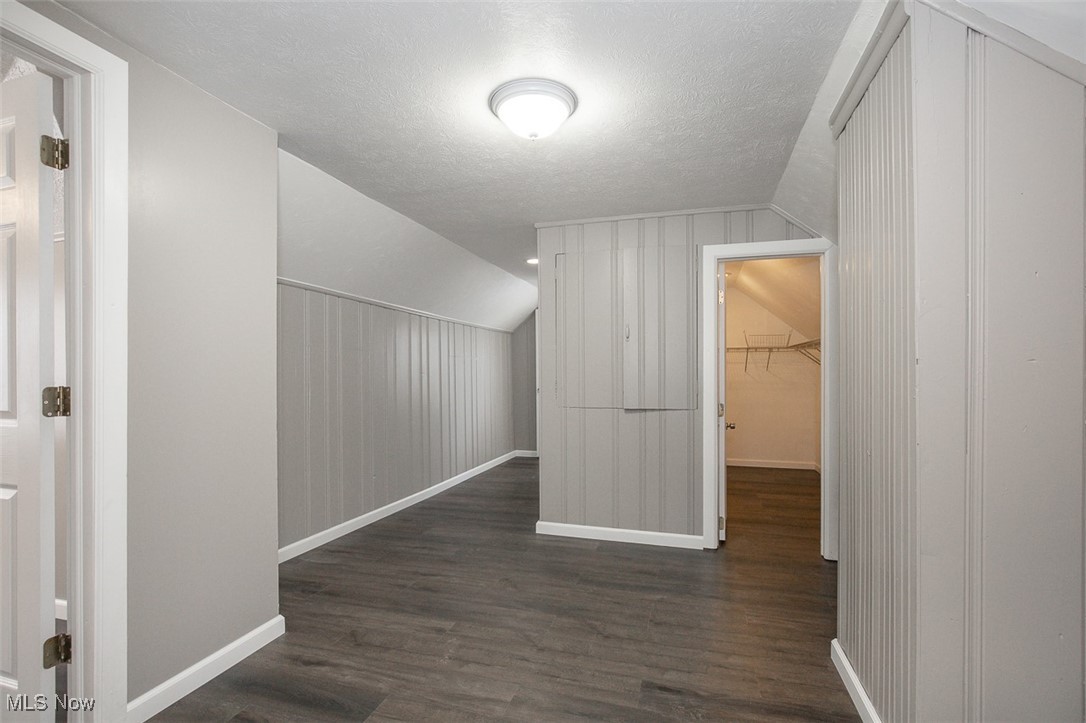 12328 Granger Road Cleveland, OH 44125 - Photo 22 of 37 Bonus room with dark wood-style flooring, vaulted ceiling, and a textured ceiling
