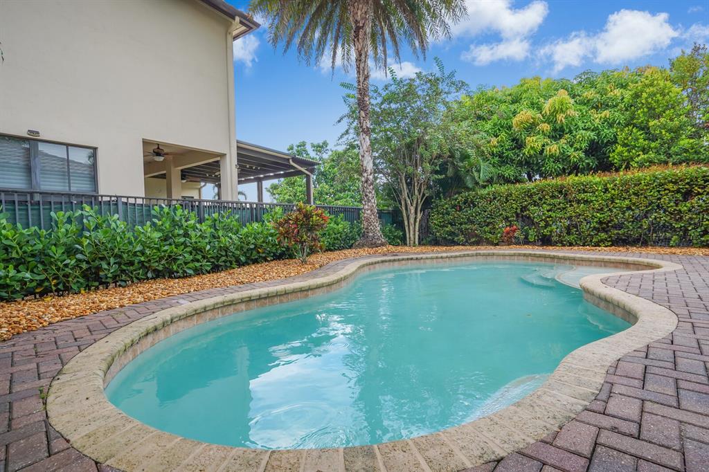 8504 Northwest 37th Court Pembroke Pines, FL 33024 - Photo 31 of 32 a swimming pool with outdoor seating and plants