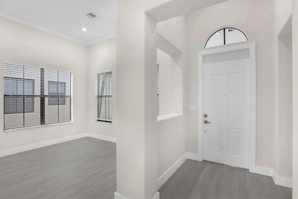 8504 Northwest 37th Court Pembroke Pines, FL 33024 - Photo 5 of 32 an empty room with wooden floor and windows