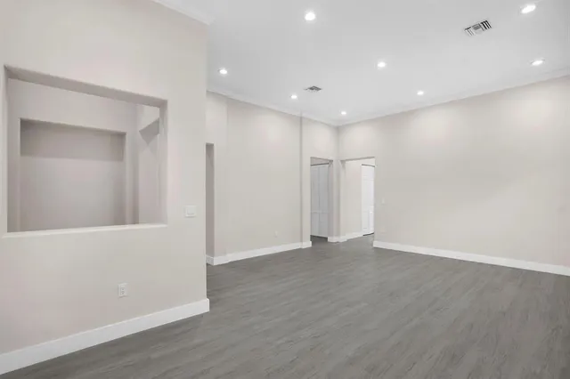 a view of an empty room with wooden floor