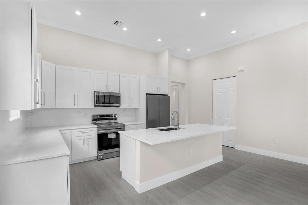 8504 Northwest 37th Court Pembroke Pines, FL 33024 - Photo 10 of 32 a large kitchen with cabinets stainless steel appliances and wooden floor