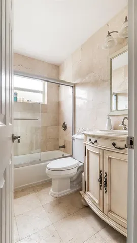 a bathroom with a double vanity sink toilet and shower