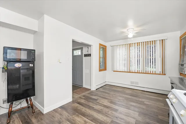 a view of an empty room with glass door and wooden floor