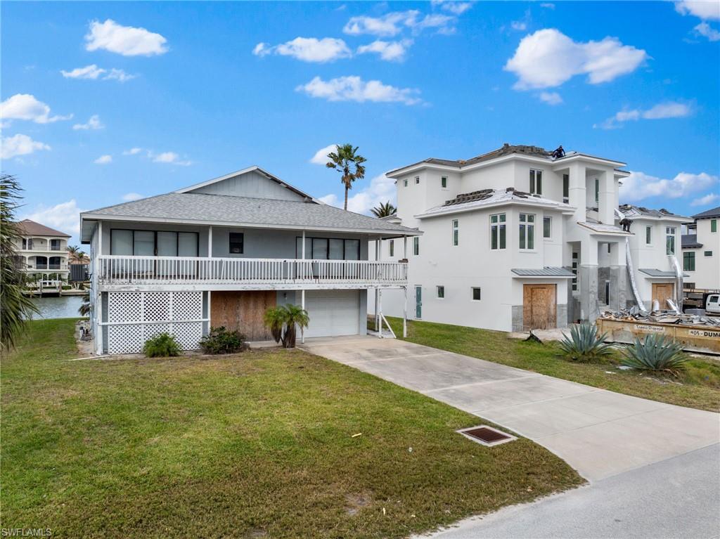 259 Trade Winds Avenue Naples, FL 34108 - Photo 6 of 9 a view of a big house with a big yard and plants