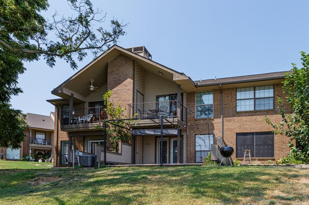 4606 Chaha Road, Unit 105 Garland, TX 75043 - Photo 25 of 26 Back of house featuring a balcony, a yard, and brick siding