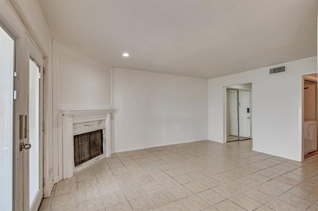 4606 Chaha Road, Unit 105 Garland, TX 75043 - Photo 6 of 26 Unfurnished living room with a fireplace, light tile patterned floors, and recessed lighting