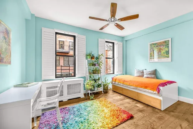 a bedroom with a bed a dresser next to a window