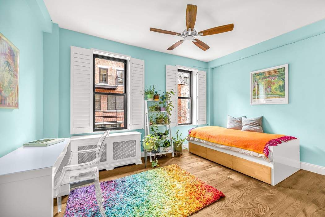 a bedroom with a bed a dresser next to a window