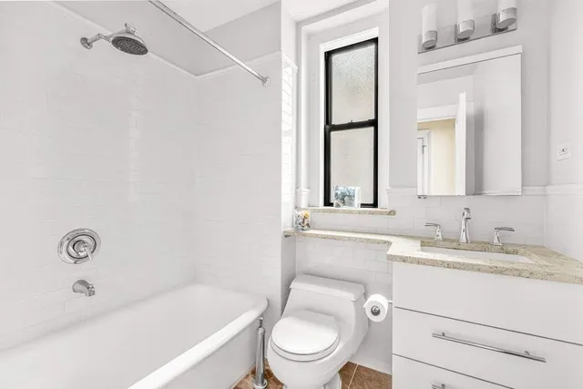 a bathroom with a toilet a sink a mirror and a bathtub