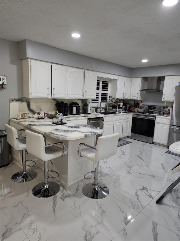 4821 Platt Road Plant City, FL 33565 - Photo 10 of 49 a kitchen with stainless steel appliances kitchen island granite countertop a sink a stove a refrigerator cabinets and chairs