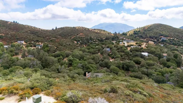 a view of a houses with a lush green hillside