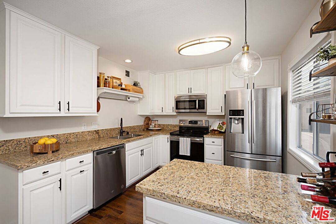 7774 Vía Rosa Maria Burbank, CA 91504 - Photo 8 of 22 a kitchen with stainless steel appliances granite countertop a refrigerator sink and stove