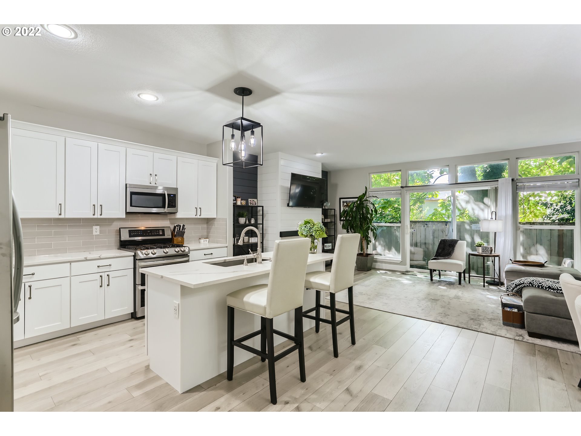 16603 Southwest 134th Terrace Portland, OR 97224 - Photo 12 of 30 a open kitchen with stainless steel appliances granite countertop a stove top oven a sink a dining table and chairs with wooden floor