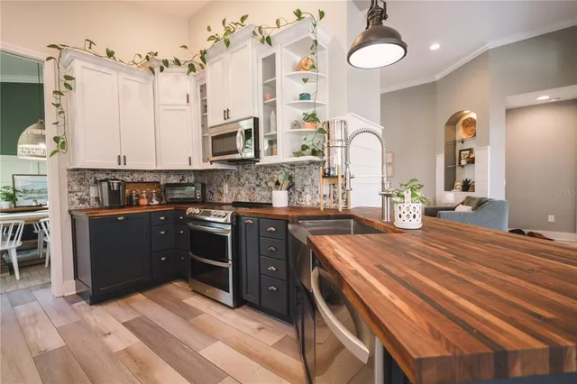 a kitchen with stainless steel appliances kitchen island granite countertop a stove a sink and a microwave