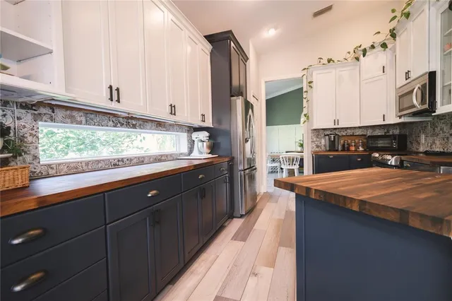 a kitchen with stainless steel appliances granite countertop a sink a stove and a microwave oven