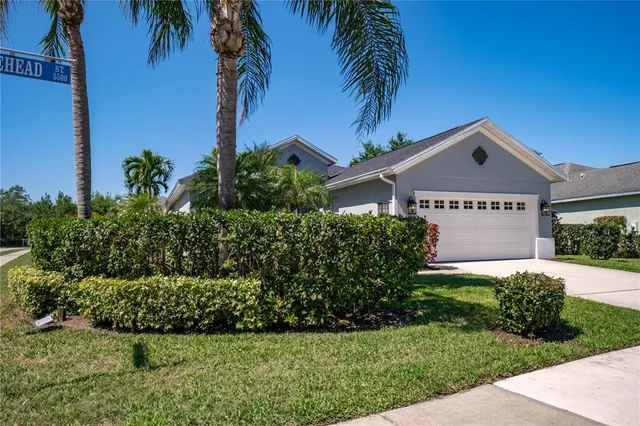 a sign board with a house in the background