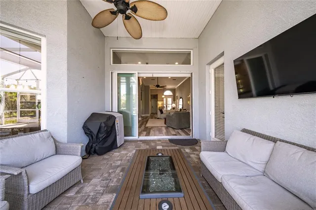 a living room with furniture a flat screen tv and a floor to ceiling window