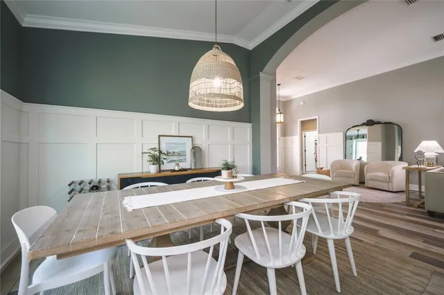 a dining room with a wooden table and chairs