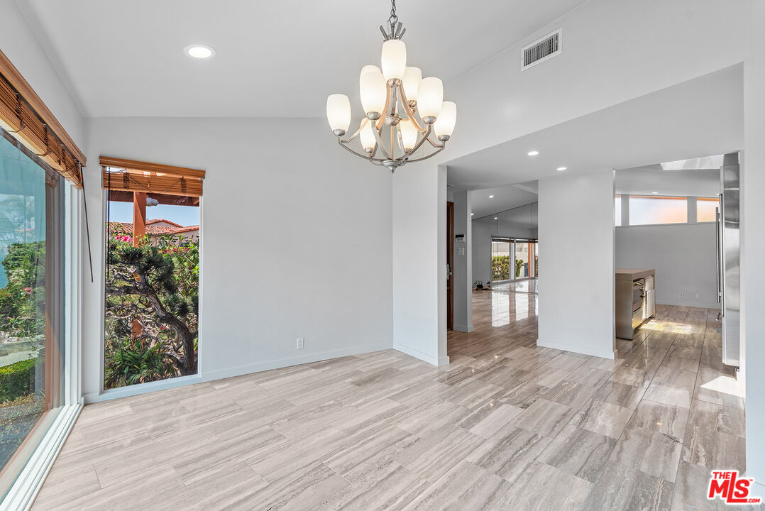 7220 Rindge Avenue Playa del Rey, CA 90293 - Photo 15 of 53 a view of an empty room with wooden floor and a kitchen
