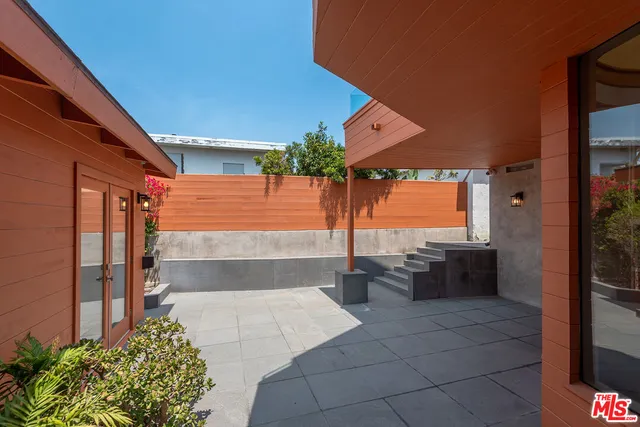 a view of a patio with table and chairs under an umbrella