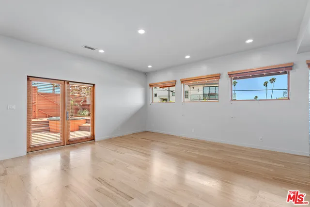 a view of an empty room with wooden floor