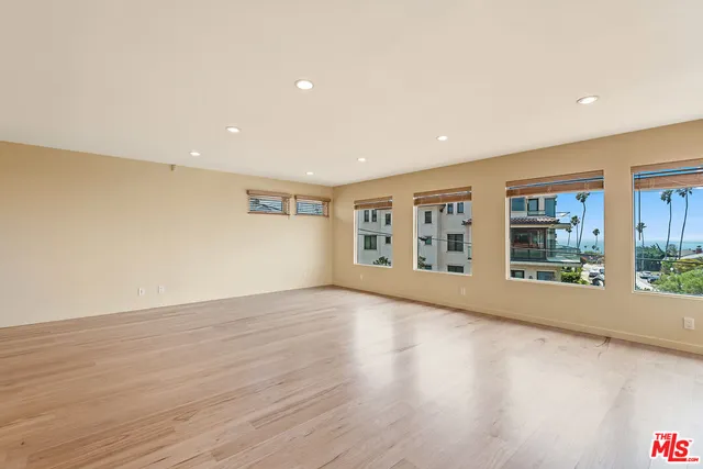 a view of an empty room with wooden floor