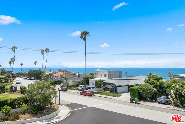 a front view of a house with a yard and potted plants