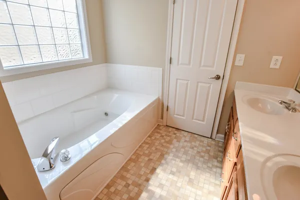 a bathroom with a tub a window and a shower
