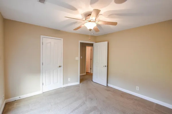 an empty room with a ceiling fan and a window