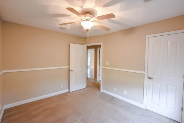 an empty room with fan and entryway