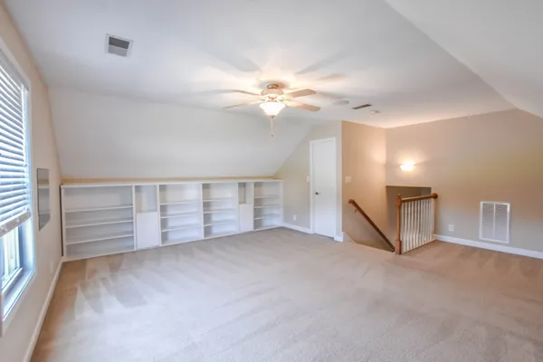 an empty room with windows and fan