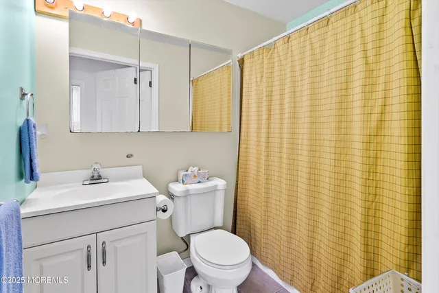 a bathroom with a sink a toilet and shower curtain