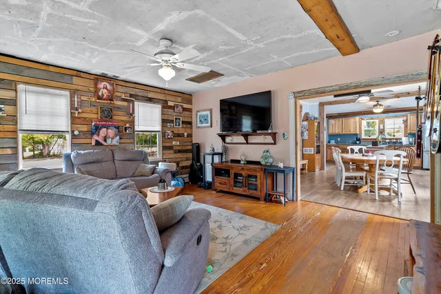 a living room with furniture and a flat screen tv with wooden floor